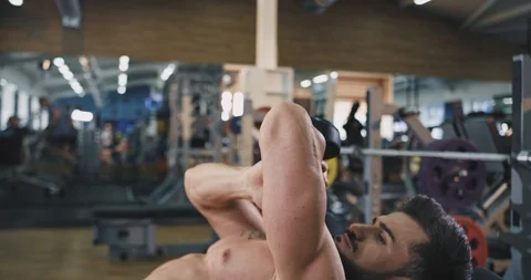 Closeup working on the gym young man pushing up the dumbbell he working on his Video stock 114764951