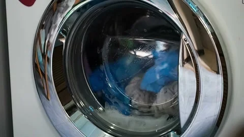 Closeup working laundry machine spinning cleaning colorful cloth colored Stock Footage 336563764