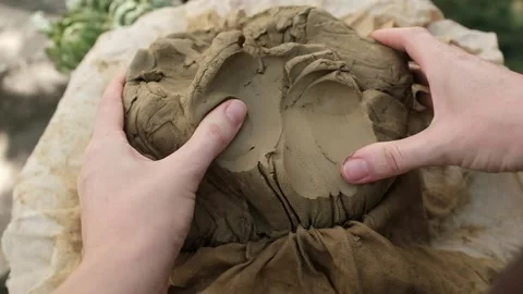 Closeup of working with wet clay. Hands separate small lumps of clay. Stock Footage 316920630