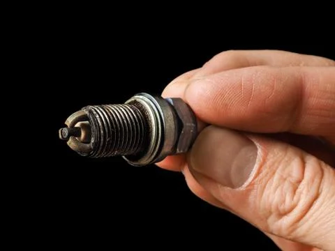 Closeup of a worn spark plug held Stock Photos