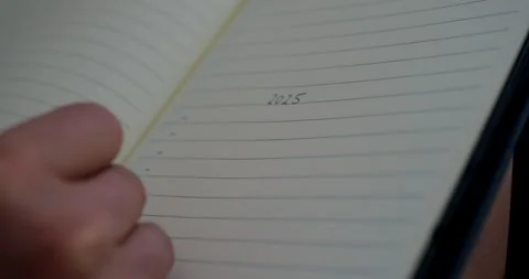 Closeup of writing 2025 goals on notepad Stockbeeldmateriaal 282761759