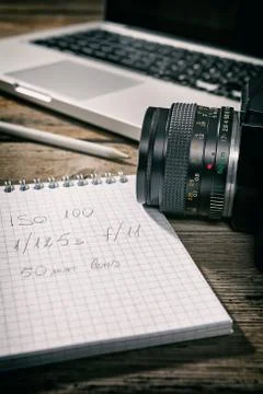 Closeup of a written notebook and a camera Stock Photos