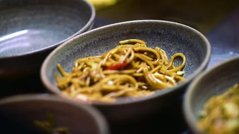 Closeup of Yakisoba stir fry chicken noodles in three rustic dishes. Stock Footage