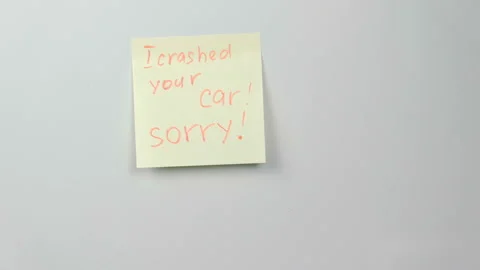 Closeup yellow sticker paper sheet with words i crashed your car, sorry on Stock Footage 88307139