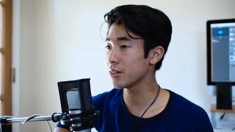 Closeup of Young Asian Man Singing into Microphone at his Home Recording Studio Stock Footage 112637328