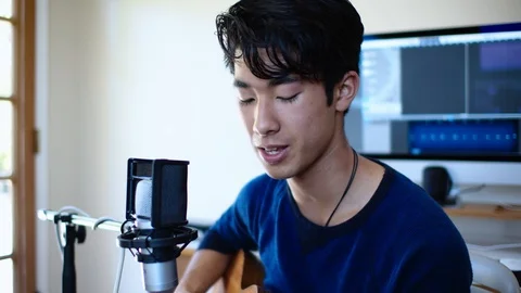 Closeup of Young Asian Man Singing into Microphone at his Home Recording Studio Stock Footage 112638026