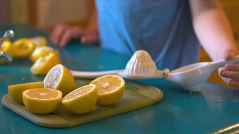 Closeup of a Young Boy Fitting a Lemon into a Press Stock Footage 94395451