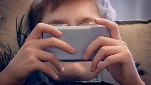 Closeup of young boy looking at smartphone. Stock Footage 106562834