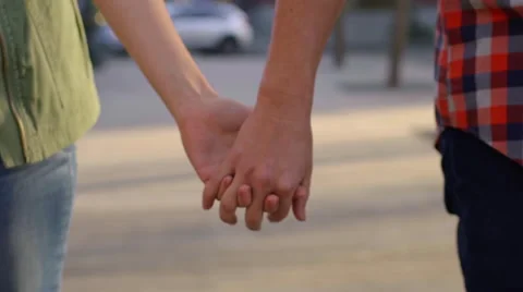 Closeup Of Young Couple's Hands As They Walk In City Park Stock Footage 61019986