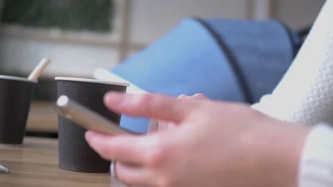Closeup of young female hands scrolling smartphone, surfing internet, in cafe Stock Footage 138882011