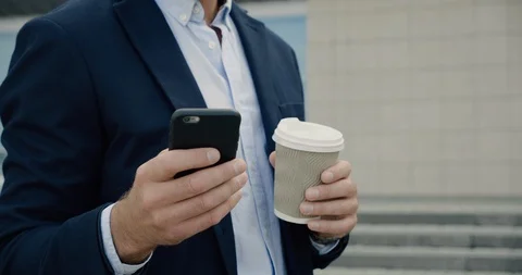 Closeup of young handsome office Manager texting Messages and drinking Coffee. Stock Footage 117690647
