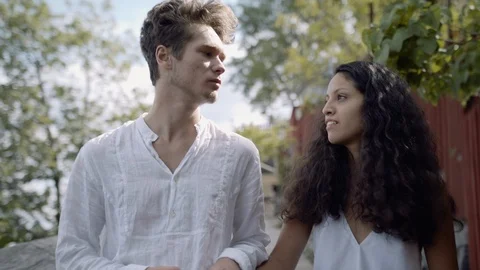 Closeup of a young happy couple smiling and walking on a rhustic road in a park. Video stock 116149448
