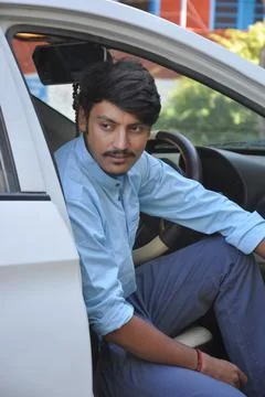 Closeup of a young Indian guy looking sideways while sitting in the car Stock Photos