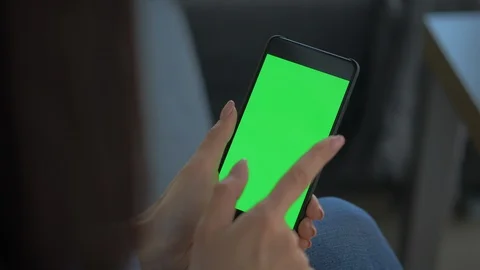 Closeup Of Young Lady Touching Green Screen On Smartphone Video stock 128368424