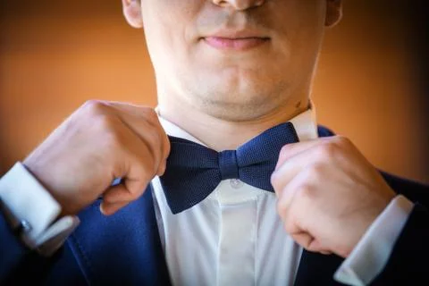 Closeup of young man adjusting bow-tie on his wedding day Stock Photos