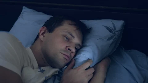 Closeup. young man in bed with open eyes suffering insomnia. Видео 129255132