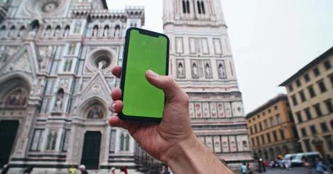 Closeup young man browsing on smartphone against famous religious landmark Stock Photos