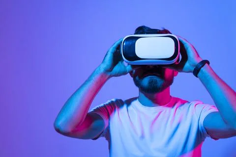 Closeup of young man developer wearing virtual reality goggles in modern studio Stockfoto's