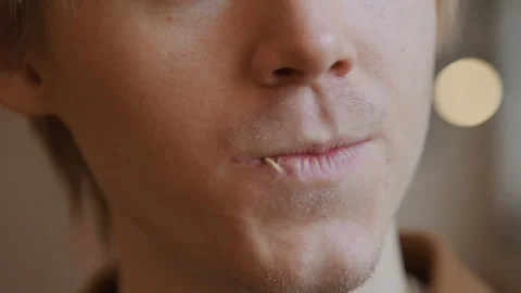 Closeup young man flossing teeth with steady hand visible skin texture and soft Stock Footage 345730632