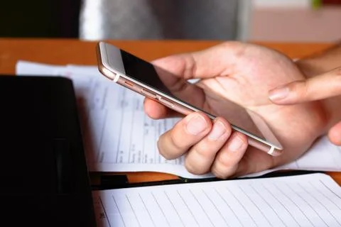 Closeup of young man hand using smartphone, laptop when working in office o.. Stock Photos