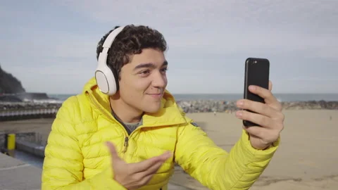 Closeup of young man having video call on phone outdoors Vídeo Stock 222571445