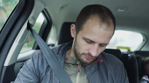 Closeup young man talking on mobile phone while riding in backseat of car 스톡 동영상 85457780