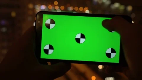 Closeup. Young man is using Smartphone with Green Screen at Evening Time in Stockbeeldmateriaal 71104695