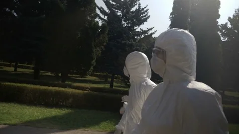 Closeup of young technicians patrol in hazmat suits walking ahead to contamin Stock Footage 82178476