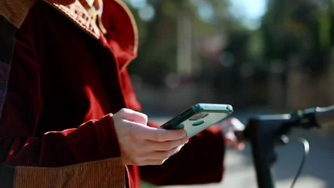 Closeup of young woman hands using smartphone riding on electric scooter Stock Footage 218256060