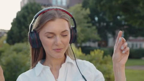 A closeup of young woman using headphone for listening nice music and walking in 스톡 동영상 289399367