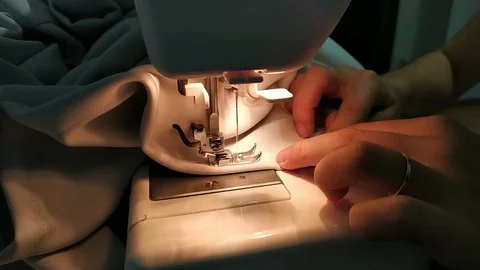 Closeup of a young woman's hands sewing with a sewing machine. Women's hands sew Stock Footage 114312326