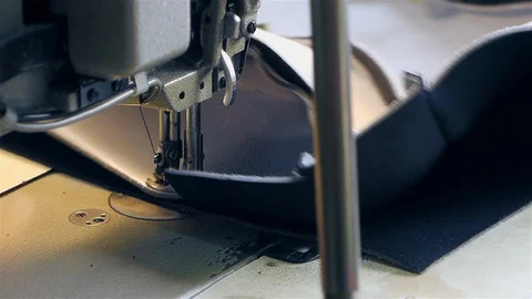 Closeup of a young woman's hands sewing with a sewing machine. Women's hands sew Stock Footage 128352574