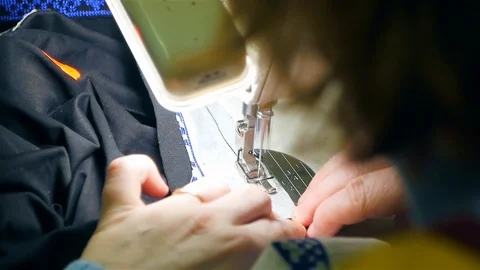 Closeup of a young woman's hands sewing with a sewing machine. Women's hands sew Stock Footage 128441829