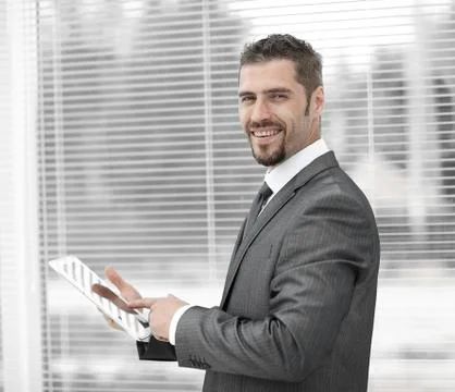 Closeup.businessman with tablet computer standing by the window. Stock Photos