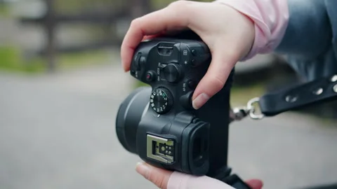 Closeyp of female hands adjusting a camera on support outdoors. Taking a picture Stock Footage 340108984