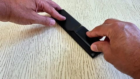 Closing the Battery Cover of TV Remote Control by Hand Stock Footage 340746768