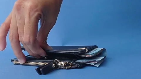 Closing the black wallet on a blue table Stock Footage 151025018
