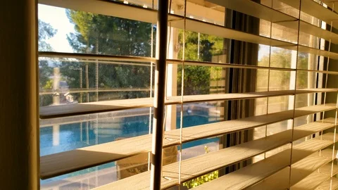 Closing the blinds by the backyard window Stock-Footage 101958490