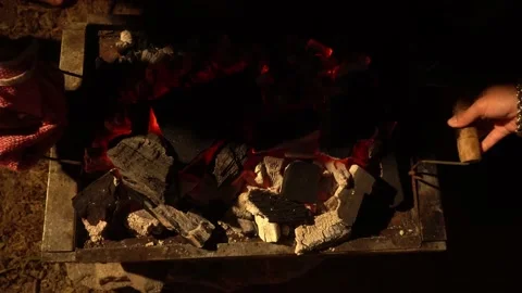 Closing a chinese box with pork inside with hot coals on a grill at night in 4k Vidéo 199594253