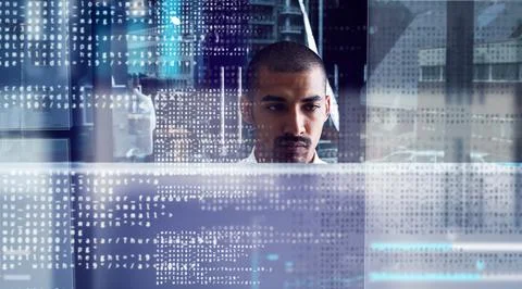 Closing in on the code. a young computer programmer looking through data. Stock Photos