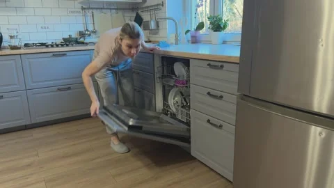 Closing dishwasher and wiping kitchen surface, Concept of home cleaning routine Stockbeeldmateriaal 341865029
