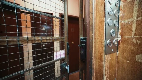 Closing door of an old stylish elevator with wooden sliding gate in Video stock 137789290