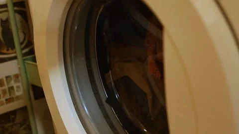Closing door of washing machine filled with dark laundry 스톡 동영상 321803250