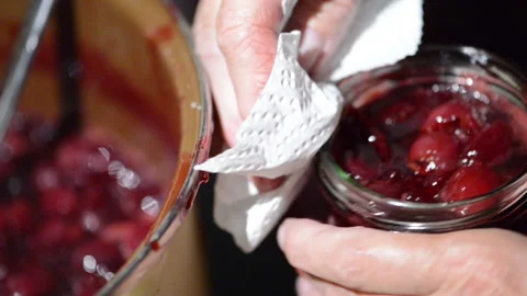 Closing glass jar of cherry fruit jam. filling into glass jar. Vídeo Stock 132436737