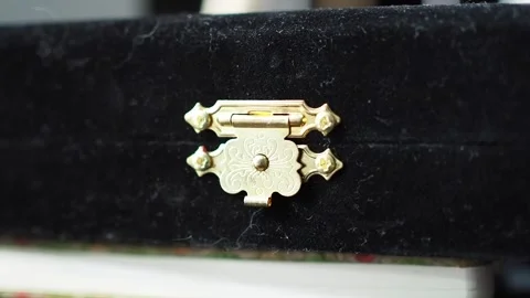 Closing golden bolt lock on black soft fabric precious box close up shot Stock Footage 282951963