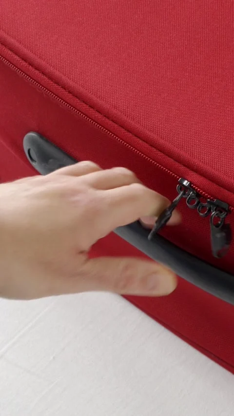 Closing her red suitcase. Видео 337033268