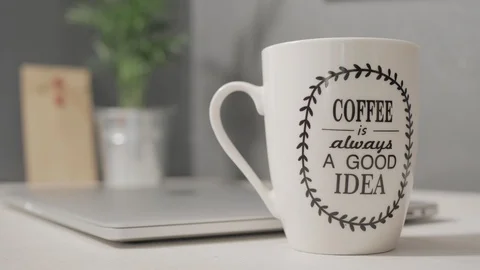 Closing a laptop with a green screen with cup of coffee in foreground Stock Footage 120594826