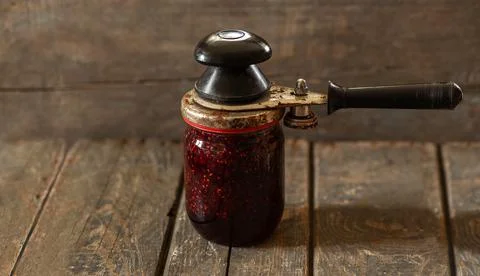 Closing the lid on a jar of raspberry jam. Preservation, cooking, food Stock Photos