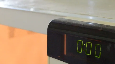 Closing the microwave door with the time count at 00 Stock Footage 114776439