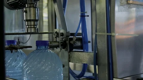 Closing plastic bottles with water on conveyor belt in modern company indoor. Stock Footage 80691767